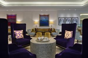 a living room with purple chairs and a table at Taj Dubai in Dubai