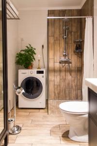 uma casa de banho com uma máquina de lavar roupa e um chuveiro. em Viö Gården em Karlskrona