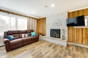 sala de estar con sofá de cuero marrón y chimenea en Quiet Country Home By Shay Lake!, 