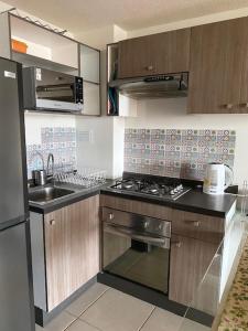 una cucina con fornelli e lavello di Departamento Costa Algarrobo Norte a Yeco