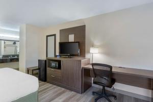 Habitación de hotel con escritorio, TV y silla en Best Western Superstition Springs Inn, en Mesa