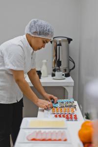 una mujer parada en una cocina preparando comida en San Miguel Awanka Hotel, en Lima