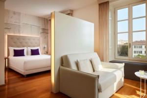 una camera con letto, divano e sedia di Avani Palazzo Moscova Milan Hotel -Previously NH Palazzo Moscova- a Milano