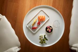 a white plate with food on top of a table at Avani Palazzo Moscova Milan Hotel -Previously NH Palazzo Moscova- in Milan