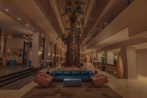 a lobby with a blue couch and a palm tree at Radisson Blu Hotel, Cairo Heliopolis in Cairo