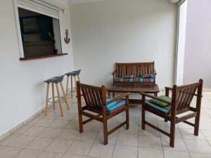 two wooden chairs and a table and a table and stool at Les terrasses de la Marina in Le Marin