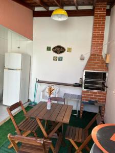 a kitchen with a table and chairs and a refrigerator at Apartamento Em Balneário Mogiano in Bertioga +11 photos