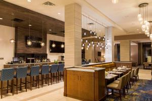 um restaurante com mesas e cadeiras e um bar em Hilton Garden Inn Minneapolis - University Area em Minneapolis