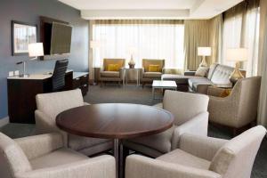 a living room with chairs and a table in a hotel room at Hilton Garden Inn Minneapolis - University Area in Minneapolis