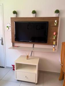 a living room with a flat screen tv on a wall at Apartamento Em Balneário Mogiano in Bertioga