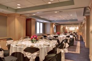 un salón de banquetes con mesas blancas, sillas y flores en The Whitehall Hotel - BW Premier Collection, en Chicago