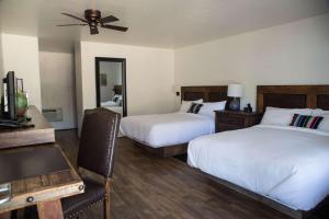 a bedroom with two beds and a table and a ceiling fan at Hacienda de Leal - BW Signature Collection in San Juan Bautista +16 photos