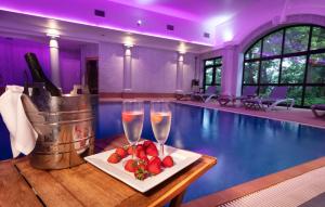 una piscina con 2 copas de champán y fresas en una mesa en Crabwall Manor & Spa - BW Signature Collection en Chester