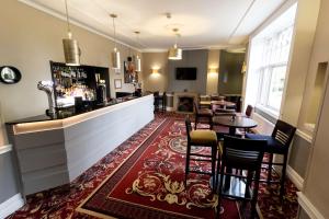 un bar en una habitación con mesa y sillas en Crabwall Manor & Spa - BW Signature Collection en Chester