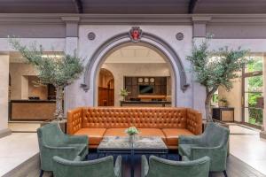 a couch in a room with a table and chairs at Oatlands Park Hotel in Weybridge