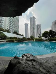 a large swimming pool in a city with tall buildings at DFT Apartment "Rockwell View" Host By HomeStay in Manila