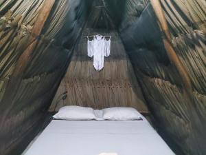 a bed in a yurt with two pillows in it at Hakuna Matata Glamping in Bacalar