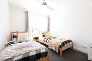 1 dormitorio con 2 camas y ventana en City Centre Unit Overlooking Ryrie Street! en Geelong