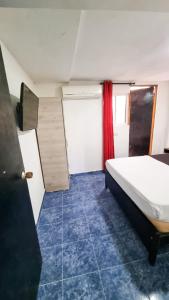 a bedroom with a bed and a red curtain at Hostel Stingray in San Andrés