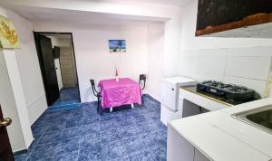 a kitchen with a table with a pink table cloth at Hostel Stingray in San Andrés