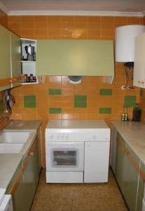 cocina con horno blanco y fregadero en Apartamento 1ª linea de mar en Sant Carles de la Ràpita