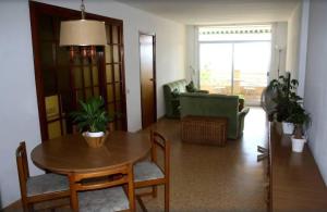 sala de estar con mesa y sofá en Apartamento 1ª linea de mar, en Sant Carles de la Ràpita