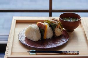 une assiette de sushis et une tasse de soupe sur un plateau en bois dans l'établissement SAKE Bar Hotel Asakusa, à Tokyo