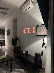 a living room with a netflix sign on the wall at Lisa Homestay, KLCC View Homestay with Home Theatre in Kuala Lumpur