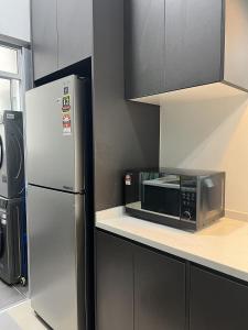 a kitchen with a microwave and a refrigerator at Lisa Homestay, KLCC View Homestay with Home Theatre in Kuala Lumpur