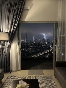 a room with a large window with a view of a city at Lisa Homestay, KLCC View Homestay with Home Theatre in Kuala Lumpur