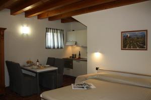 a room with a kitchen and a table with chairs at Antica Corte la Valle in Sona