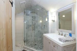 a bathroom with a shower with a sink and a mirror at Gem in Midtown 4bedroom home-11 in Atlanta
