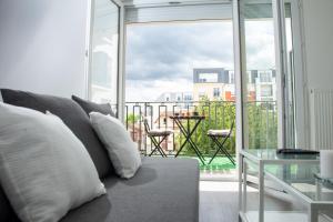 a living room with a couch and a large window at Hébergement touristique de luxe proche de Paris avec parking gratuit, situé face au parc des expositions et de l'aéroport du Bourget, à 15 min de CDG in Le Blanc-Mesnil