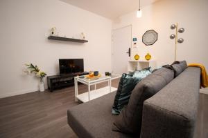 Una sala de estar con un sofá y un televisor. en Hébergement touristique de luxe proche de Paris avec parking gratuit, situé face au parc des expositions et de l'aéroport du Bourget, à 15 min de CDG, en Le Blanc-Mesnil