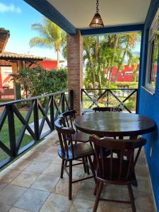une terrasse couverte avec une table et des chaises en bois sur un balcon dans l'établissement Condomínio Arituba Tropical, à Nísia Floresta