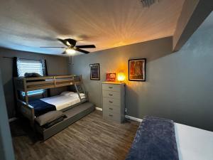 een slaapkamer met een stapelbed en een plafondventilator bij Hess St in San Antonio