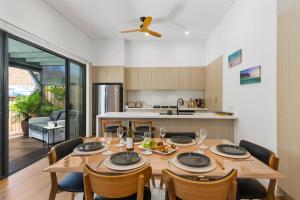 cocina y comedor con mesa y sillas en Avenue Escape - Contemporary Living at Corrimal, en Corrimal