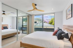 a bedroom with two beds and a ceiling fan at Avenue Escape - Contemporary Living at Corrimal in Corrimal