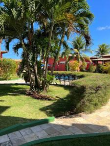 een park met palmbomen en een rood gebouw bij Condomínio Arituba Tropical in Nísia Floresta