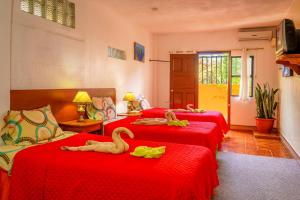 a room with three beds with swans laying on them at Hospedaje Germania in Puerto Ayora