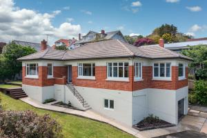 a house with a red brick at Stunning Family Home in Andersons Bay in Dunedin