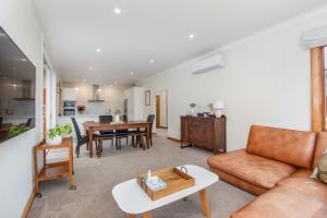sala de estar con sofá y mesa en Stunning Family Home in Andersons Bay en Dunedin