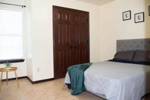 a bedroom with a bed and a brown door at Modern 2 bed 2-bath next to University UTRGV in Edinburg