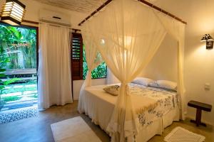 a bedroom with a canopy bed in front of a window at Villa de Bemposta-Trancoso in Trancoso +51 photos