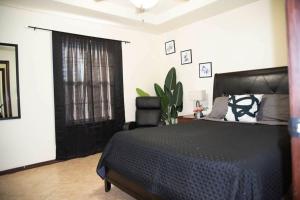 a bedroom with a black bed and a window at 1 Min to University UTRGV 2BD 2BT town suite in Edinburg