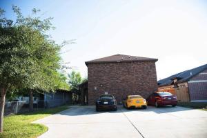 two cars parked in a parking lot next to a brick building at 1 Min to University UTRGV 2BD 2BT town suite in Edinburg