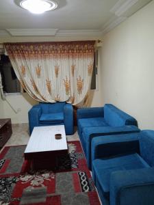- un salon avec deux canapés bleus et une table dans l'établissement HeliopolisStar, au Caire