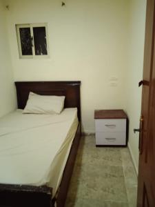 - une petite chambre avec un lit et une table de chevet dans l'établissement HeliopolisStar, au Caire
