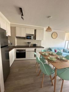 cocina y sala de estar con mesa y sillas en Depto nuevo a pasos de la playa, en La Serena