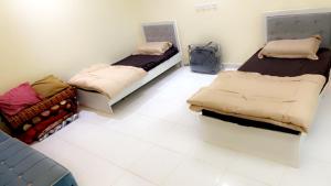 una camera con due letti e uno zaino sul pavimento di استراحات يمك دروبي a Madain Saleh